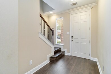 Foyer entrance featuring crown molding and dark ha