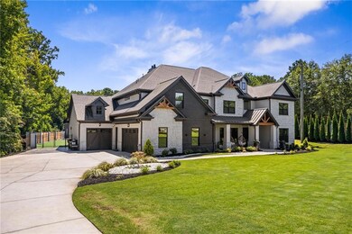 Modern farmhouse style home with stone siding, a garage, concrete driveway, a standing seam roof, and a metal roof