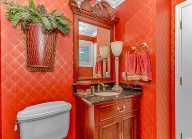 Bathroom with crown molding, vanity, and toilet
