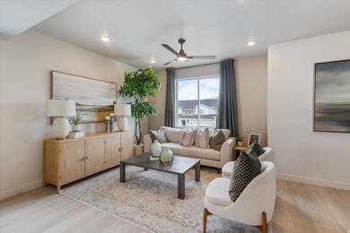 Living area featuring light wood-style floors, a ceiling fan, and recessed lighting