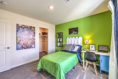 Bedroom with carpet flooring, a spacious closet, and an office area