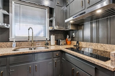 Kitchen with sink, black electric cooktop, gray ca