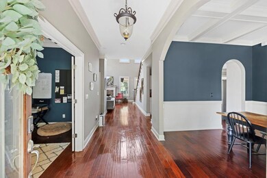 Hall featuring arched walkways, hardwood / wood-st