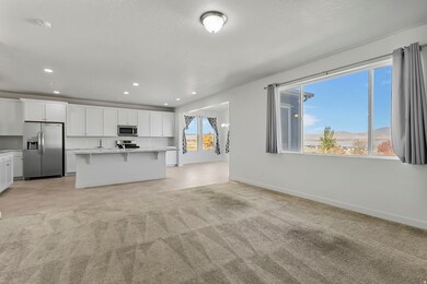 Kitchen featuring stainless steel appliances, white cabinets, a kitchen bar, open floor plan, and a kitchen island with sink