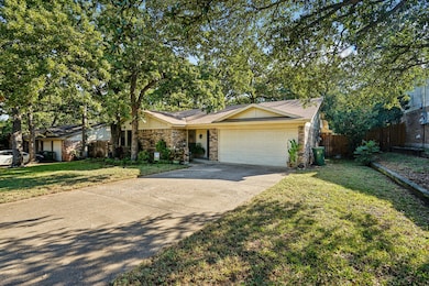 View of front of home with driveway, a garage, brick siding, and roof with shingles