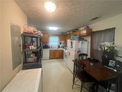 Kitchen with a textured ceiling, visible vents, br