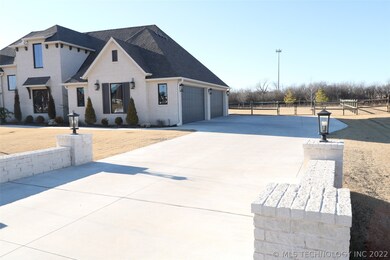 Large driveway access to 4-car garage and gate to