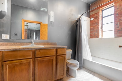 Bathroom featuring shower / bath combo with shower curtain, vanity, and light tile patterned floors