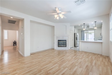 Unfurnished living room featuring ceiling fan, lig