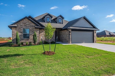 View of front of property featuring driveway, a garage, a front yard, brick siding, and roof with shingles