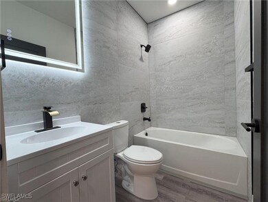 Full bath featuring wood finished floors, toilet,