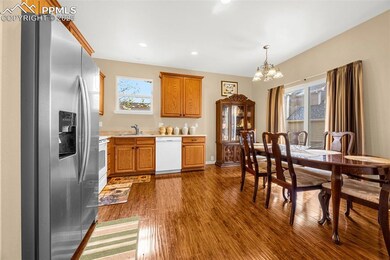 Kitchen featuring white appliances, a chandelier, light countertops, dark wood-style floors, and a sink