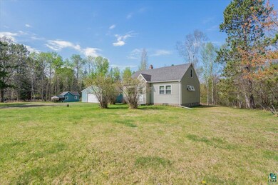 View of front of property featuring a front yard, a detached garage, and a chimney