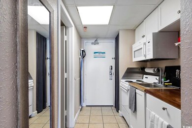 Kitchen with light tile patterned flooring, a drop
