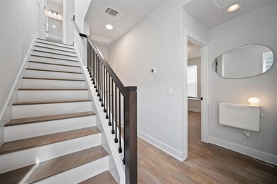 Staircase featuring wood finished floors and rece
