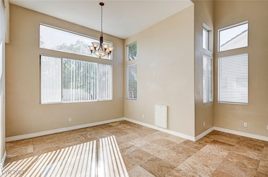 Unfurnished dining area featuring a chandelier and a high ceiling