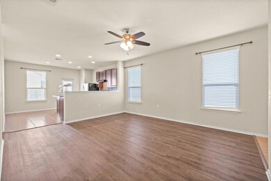 Unfurnished living room with ceiling fan, dark wo