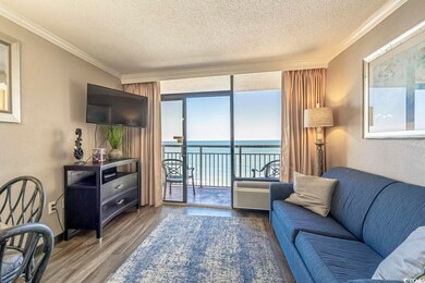 Living room featuring ornamental molding, expansive windows, a textured ceiling, and wood finished floors