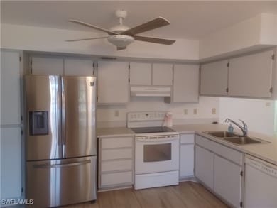 Kitchen with white appliances, under cabinet range