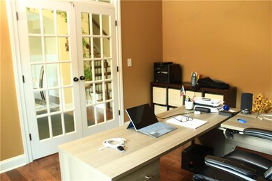 Office with dark wood finished floors and french doors