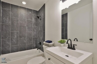 Full bathroom featuring vanity, toilet, and tiled 