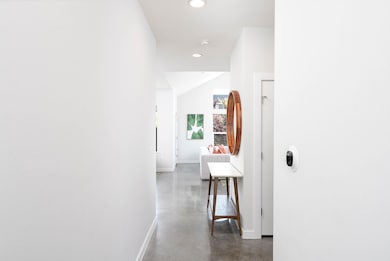Hallway with concrete flooring and recessed light