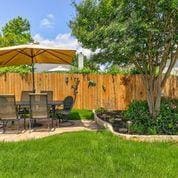 View of yard with outdoor dining area and a patio
