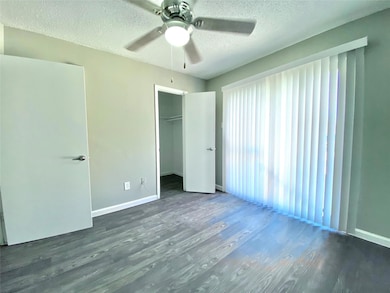 Unfurnished bedroom featuring baseboards, a textur