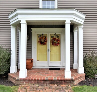 Gracious columned entry with brick flooring