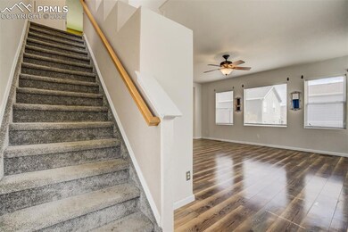 Staircase with baseboards, wood finished floors, a