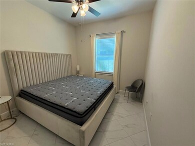 Bedroom featuring light marble finish flooring and ceiling fan