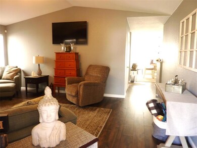 Living room with lofted ceiling and dark hardwood 