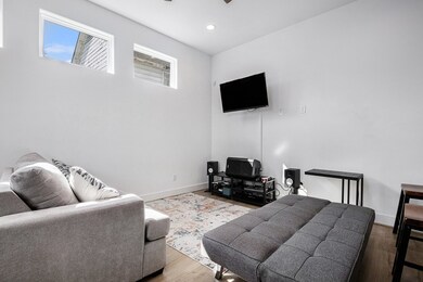 Cozy living area with modern. Features bright natural light from high windows. Ideal for relaxing and entertaining.