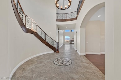 Foyer featuring stone tile flooring, stairway, arc