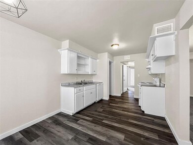 Kitchen featuring white cabinets, dark hardwood / 