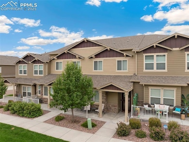 Multi unit property with board and batten siding, outdoor lounge area, roof with shingles, and a patio area