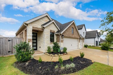 This gorgeous home has lovely curb appeal, a well-manicured lawn, beautiful landscaping, brick elevation, dark stained front door, covered front porch, traditional style.
