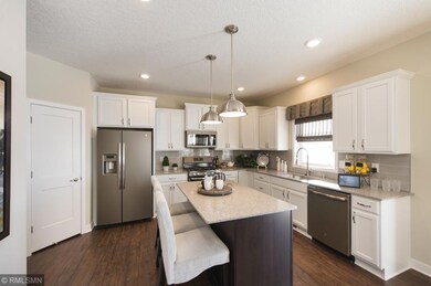 The quartz countertops are accented by the beautiful glass tile backsplash. Stylish slate appliances to include a gas range are all included.