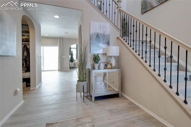 Staircase featuring arched walkways, wood finished floors, and recessed lighting