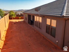 View of home's exterior with a fenced backyard, stucco siding, and a patio