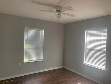 Spare room featuring dark wood-style flooring and ceiling fan