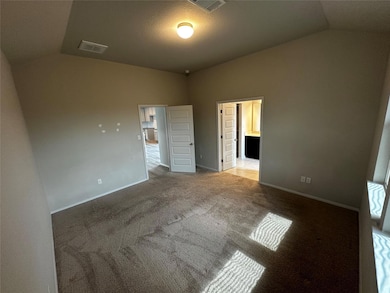 Unfurnished bedroom featuring ensuite bathroom, carpet flooring, and lofted ceiling