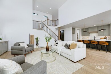 Living room with light wood-style floors, a towering ceiling, stairs, and recessed lighting