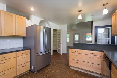 The beautifully designed kitchen provides plenty of counter space and cabinetry.  The front entry leads to both kitchen and living area.