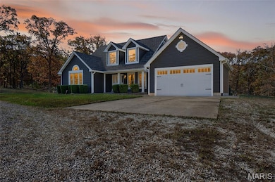 View of front of home with concrete driveway, covered porch, a yard, and a garage