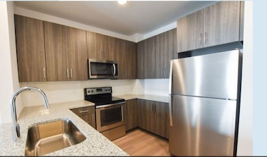 Kitchen featuring light stone countertops, stainle