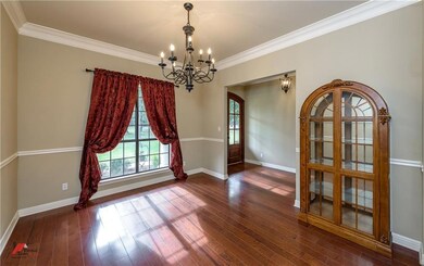 Formal dining boasts hardwood flooring and crown m