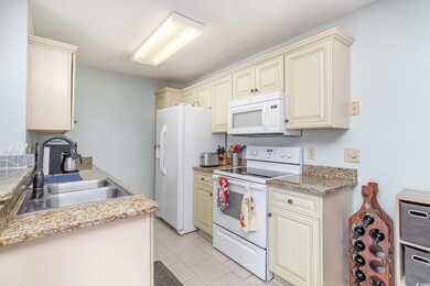 Kitchen with light tile patterned floors, cream ca