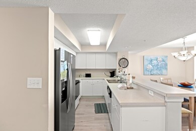 Kitchen featuring stainless steel fridge with ice dispenser, light countertops, light wood-style flooring, a peninsula, and white cabinets