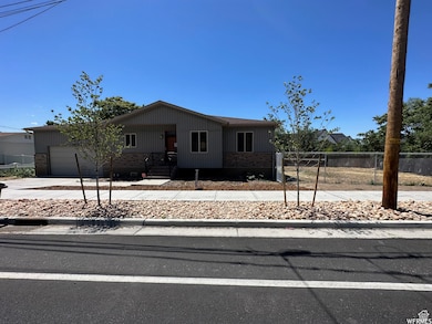 View of front of property featuring brick siding, concrete driveway, and a garage
